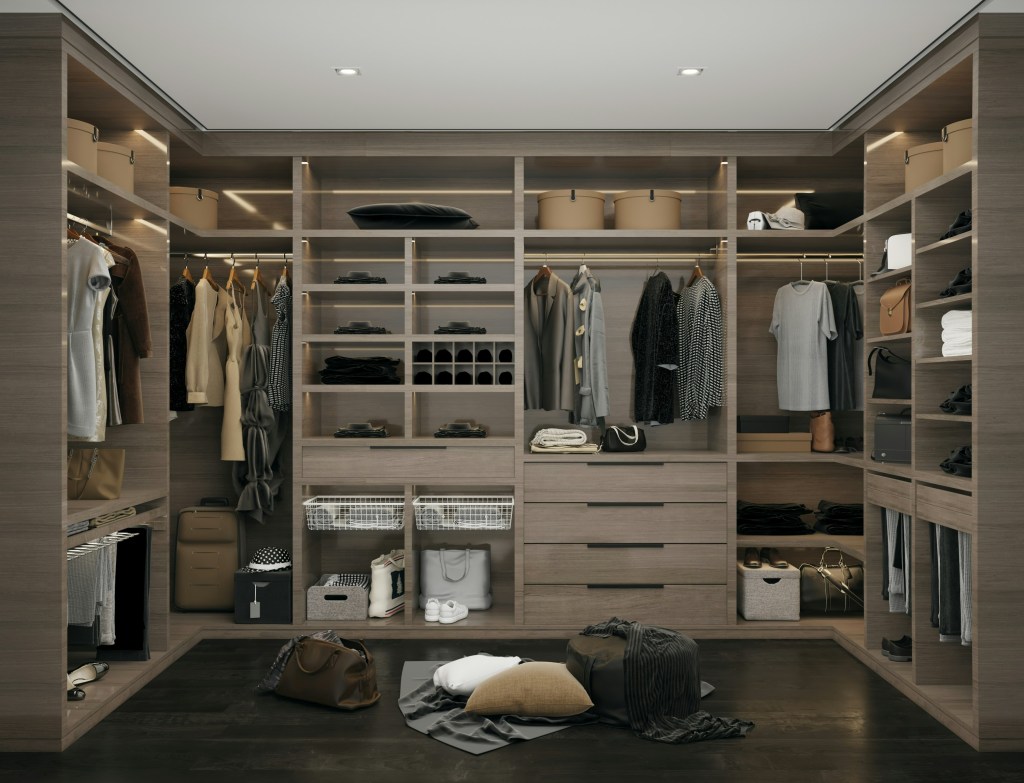 Interior view of a dimly lit, overflowing walk-in wardrobe. Clothes are slightly disorganized on racks, emphasizing the depth and volume of concealed possessions. A single, ornate mirror in the center reflects a messy, unedited truth.