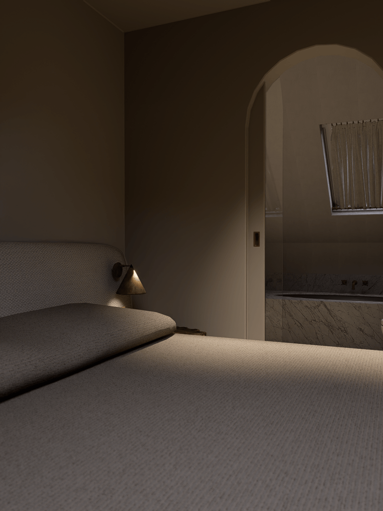 A nighttime view of a minimalist master bedroom in Saddleworth looking through a soft-arched doorway into a lit marble ensuite.